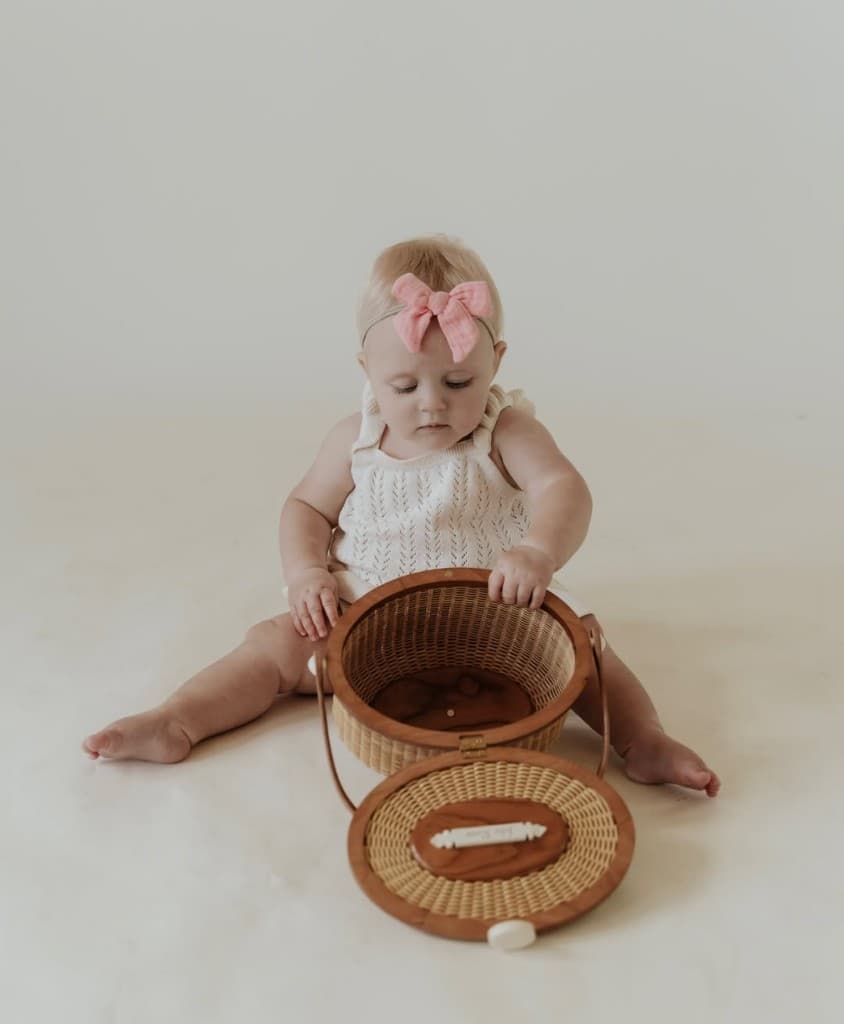 Baby with a handwoven Nantucket basket by Chatham Weaves